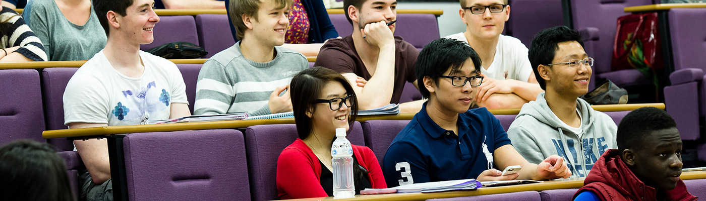 Students smiling in a lecture theatre